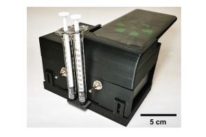 The microfluidic cartridge can be inserted into a portable device that also has a cradle for a smartphone, so the phone's camera can read the test results.