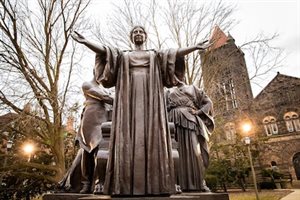 Alma Mater faithfully greets the campus community of the University of Illinois at Urbana-Champaign. Alma, a 10,000-pound bronze statue by sculptor Lorado Taft, depicts a mother-figure wearing academic robes and flanked by two attendant figures representing &quot;Learning&quot; and &quot;Labor&quot;, after the University's motto &quot;Learning and Labor.&quot;